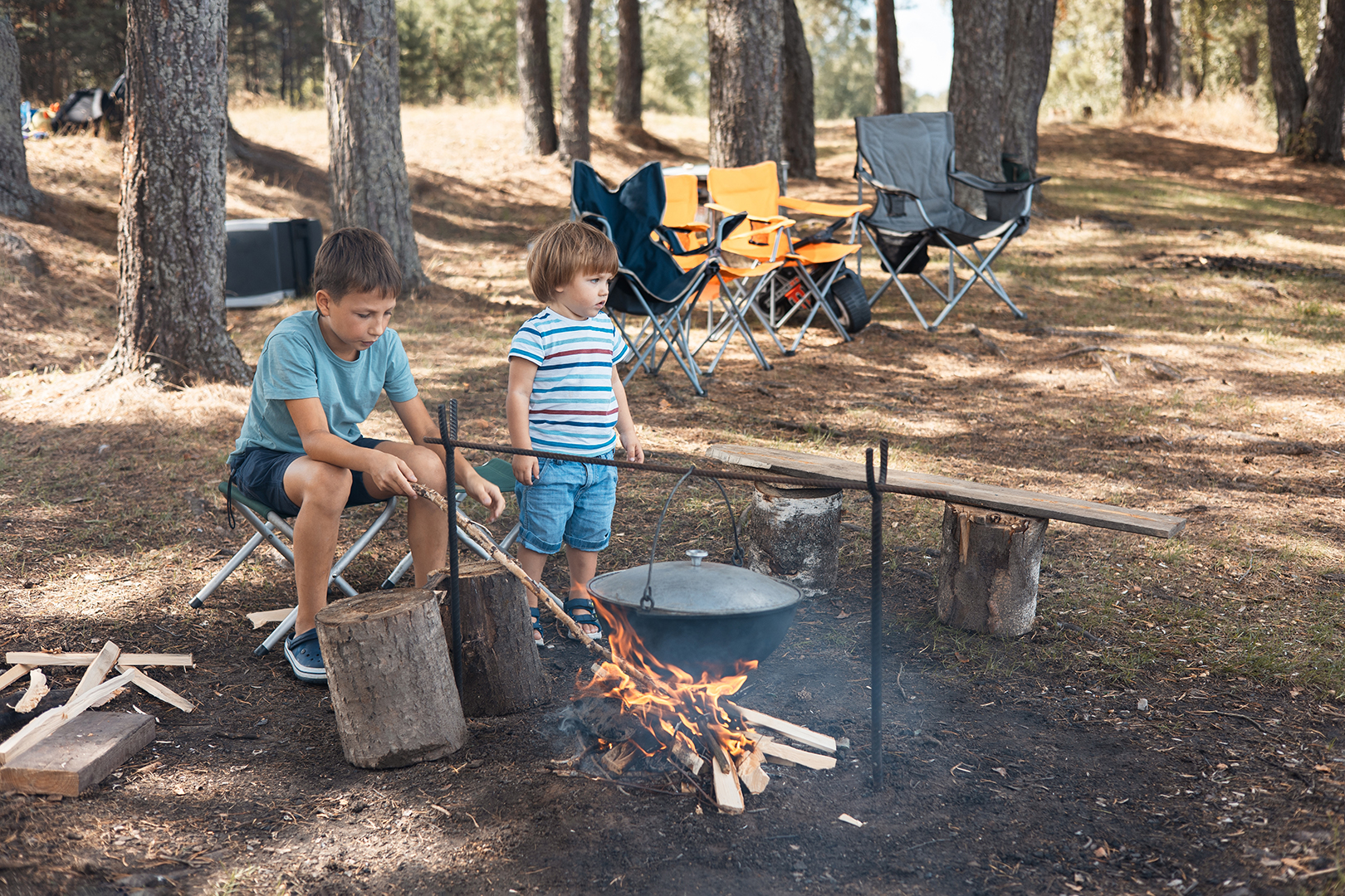 children sitting around a campfire in forest